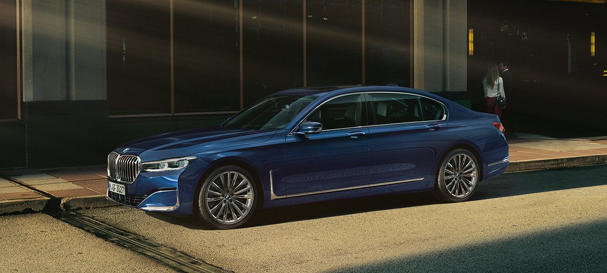 BMW Série 7 Berlina BMW Individual, perspetiva lateral Perspetiva lateral em frente a um cenário urbano do BMW Série 7 Berlina BMW Individual em vermelho