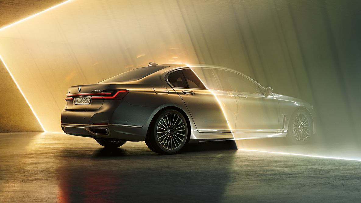 BMW Série 7 Berlina em cinza Bernina BMW Série 7 Berlina em cinza Bernina, com perspetiva traseira a três quartos, rodeado por um feixe de luz