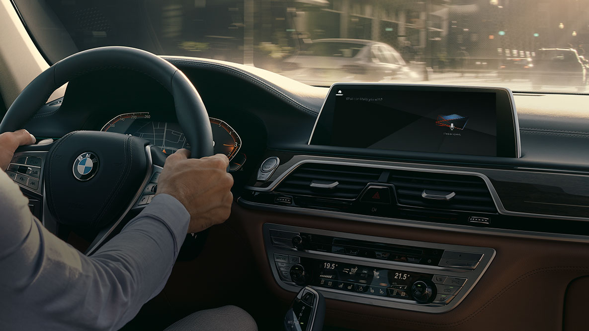 Assistente pessoal inteligente BMW Assistente pessoal inteligente BMW: homem a conduzir o seu BMW, grande plano do Live Cockpit Professional